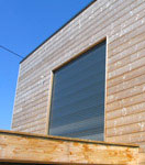 Vue extérieure de la construction d'une maison ecologique en bois réalisée avec un mur pré-fabriqué (menuiseries intégrées)