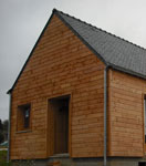 Vue extérieure de la maison ecologique en brique G7 avec un bardage bois